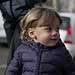 Cute little toddler walking in street sidewalk outside with mom