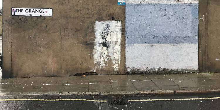 A board covers where the Banksy artwork used to be on The Grange