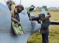 A Reconnaissance Spitfire pilot watches on as groundcrew load a reconnaissance camera into his Spitfire at RAF Benson. (Public source colourised by Colour by RJM)